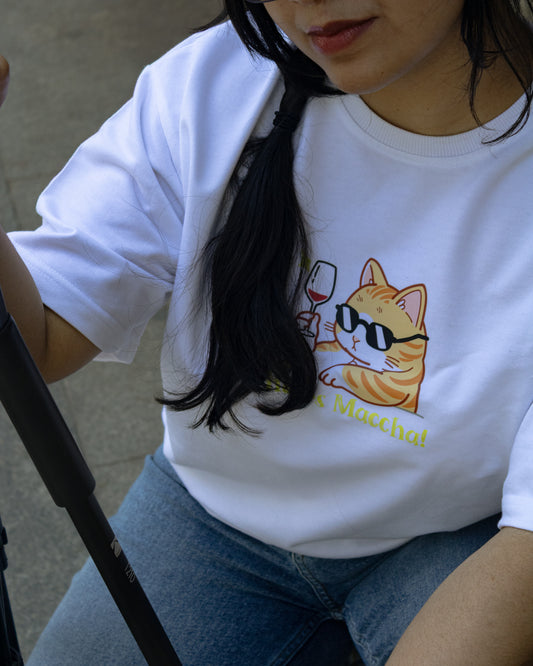 Front view of a person wearing a white, heavy French Terry cotton oversized t-shirt with a relaxed fit, featuring a high-quality graphic print on the front of an orange tabby cat wearing black sunglasses and holding a wine glass.